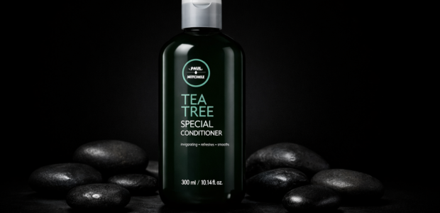 Paul Mitchell Tea Tree Special Conditioner centered on a black background with spa stones