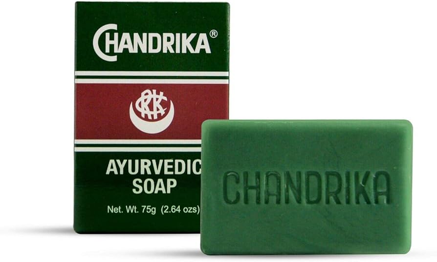 Chandrika Ayurvedic Bar Soap with herbal ingredients and person using soap in background