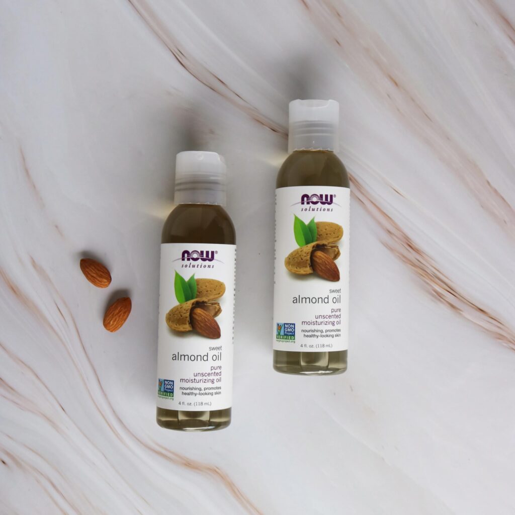 NOW Foods Sweet Almond Oil for skin and hair held by woman
